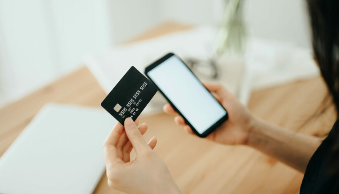 Woman shopping online with smartphone and credit card on hand