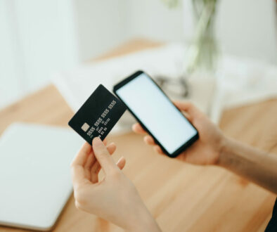 Woman shopping online with smartphone and credit card on hand
